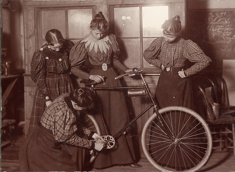 Mujeres victorianas reparando una bicicleta